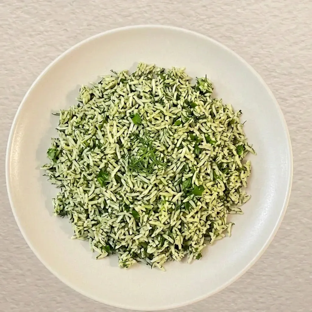 Sabzi polo — Persian basmati rice tossed through fresh dill, parsley and coriander, served on a white ceramic plate
