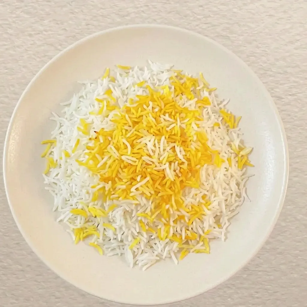 Fluffy Persian basmati rice topped with bright saffron-stained grains, served on a white ceramic plate